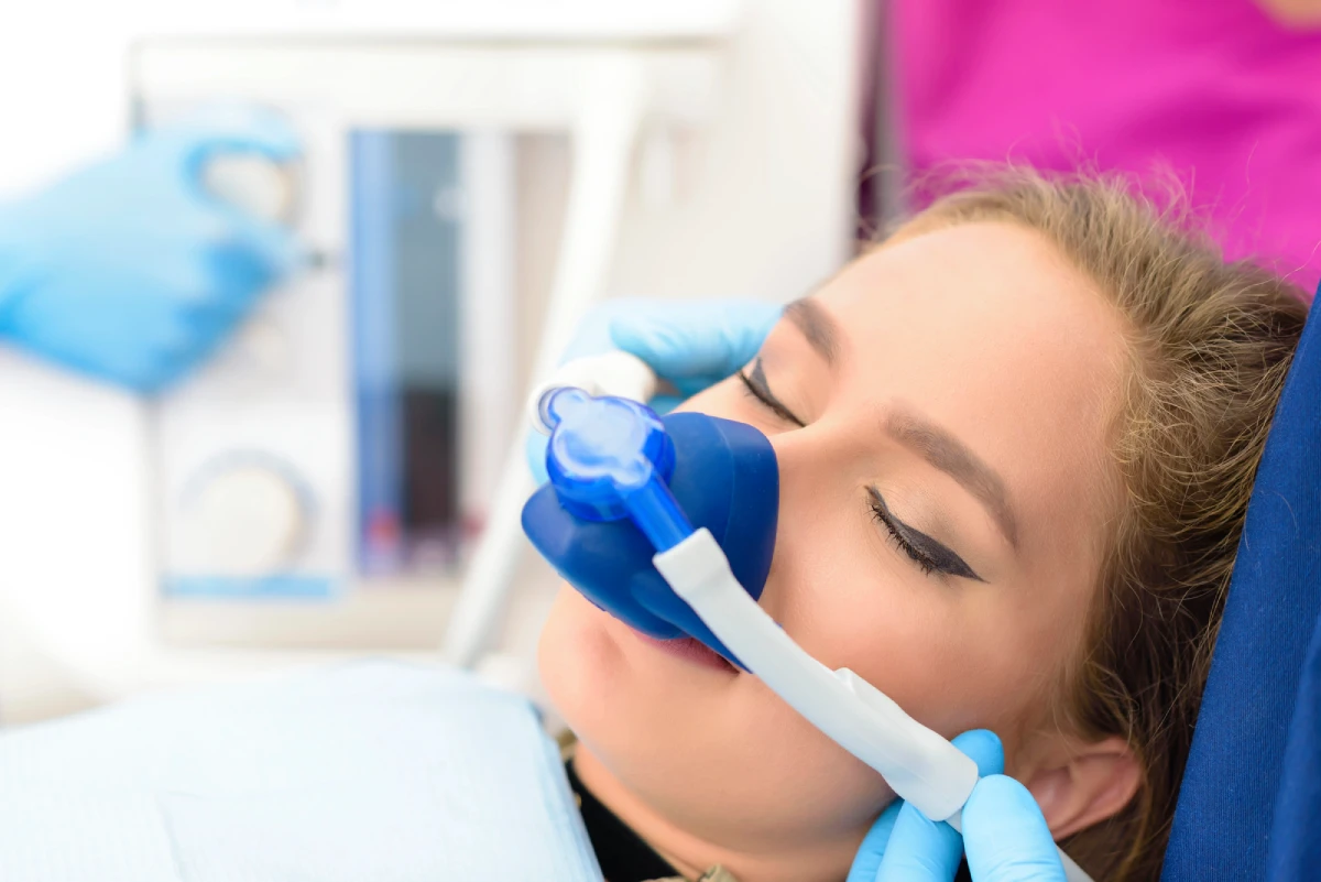 Patient receiving nitrous oxide sedation through a comfortable nasal mask during a dental procedure in Montgomery County.