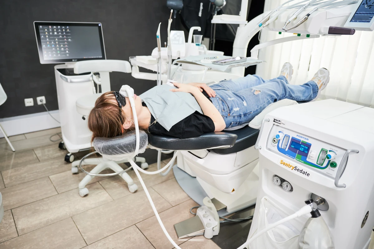 Patient relaxing in a modern dental chair while receiving nitrous oxide sedation before treatment.