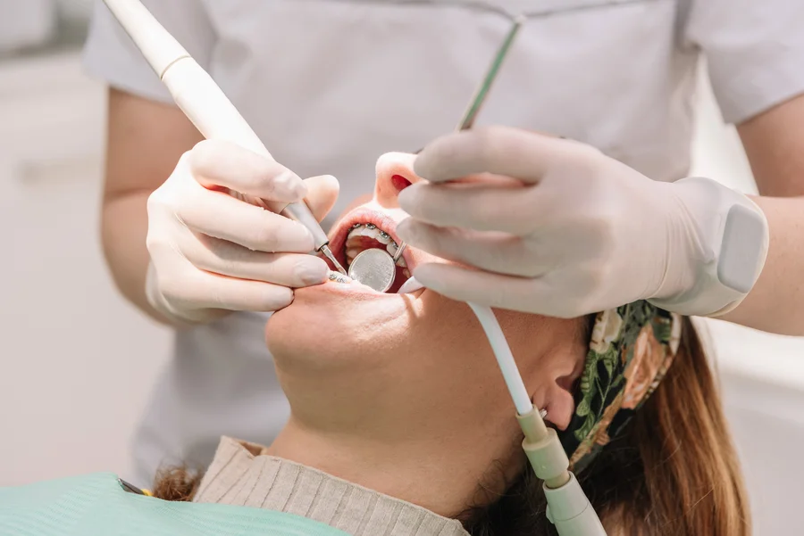 deep-teeth-cleaning-with-anesthesia-cost-dentist-treating-patient-with-braces