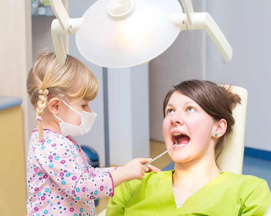 special-needs-dentist-maryland-little-girl-in-a-mask-playing-dentist-with-a-mouth-mirror